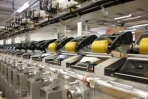 Pracownik nóg w fabryce nici