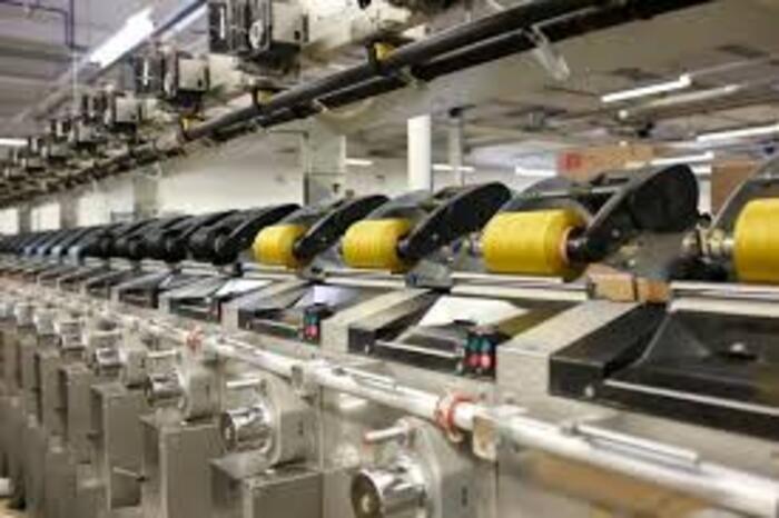 Pracownik nóg w fabryce nici